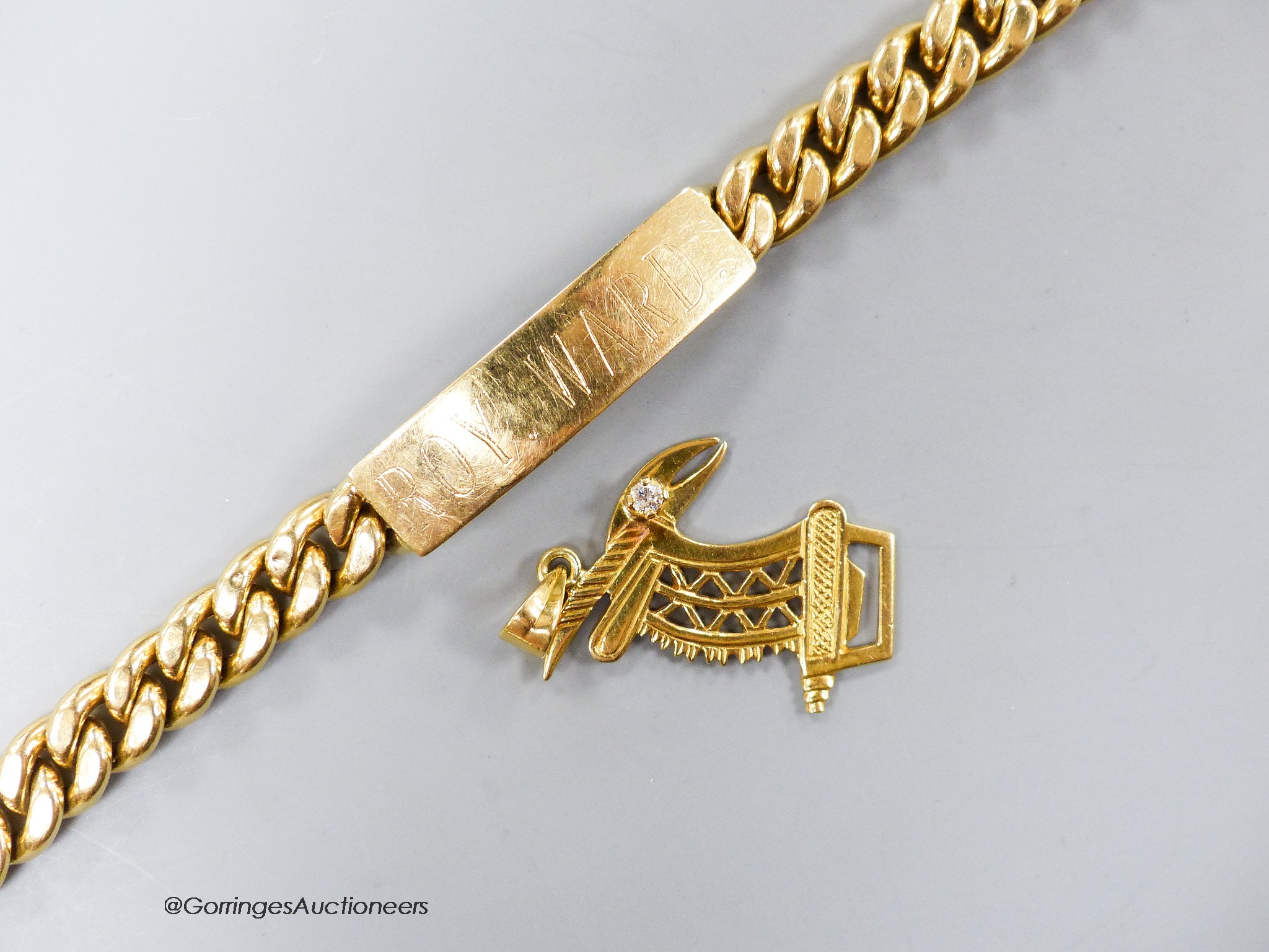 A yellow metal (stamped 750) curb link identity bracelet, 21cm and a 750 and diamond set pendant, 35mm